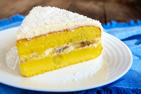 甜美的海绵蛋糕加奶油香蕉层上顶洒椰子喜悦图片