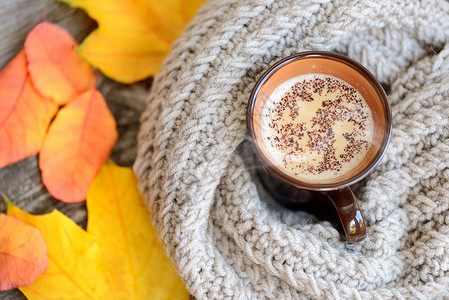 秋叶热咖啡和木桌背景的温暖围巾咖啡周日休息和静止生命概图片