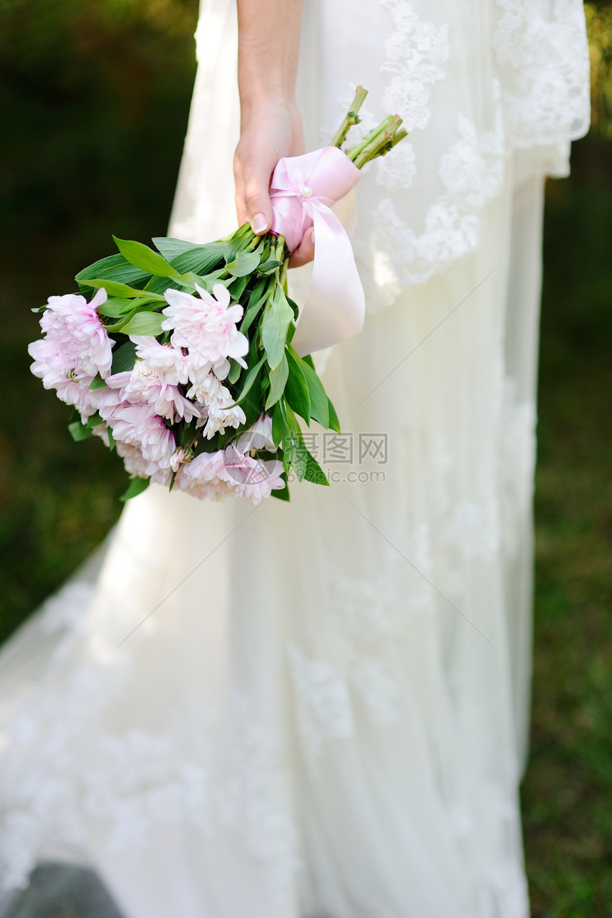 新娘在结婚礼服的背景上举行婚礼图片