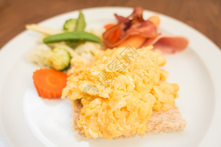 白盘中的鸡蛋培根香肠和蔬菜早餐图片