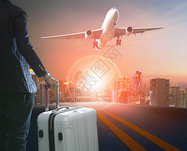 商人和旅行李站在天际线和客机接管机场跑道图片