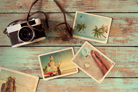 木桌上的旅行蜜月旅行夏季相册老式相机的即时照片复图片