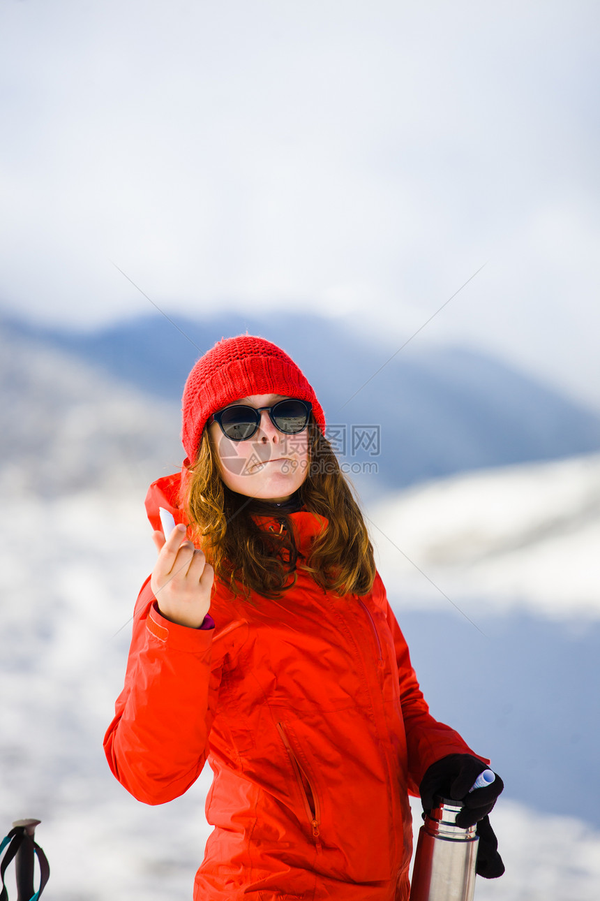 女登山者冬天在山里使用唇膏在山里寒图片