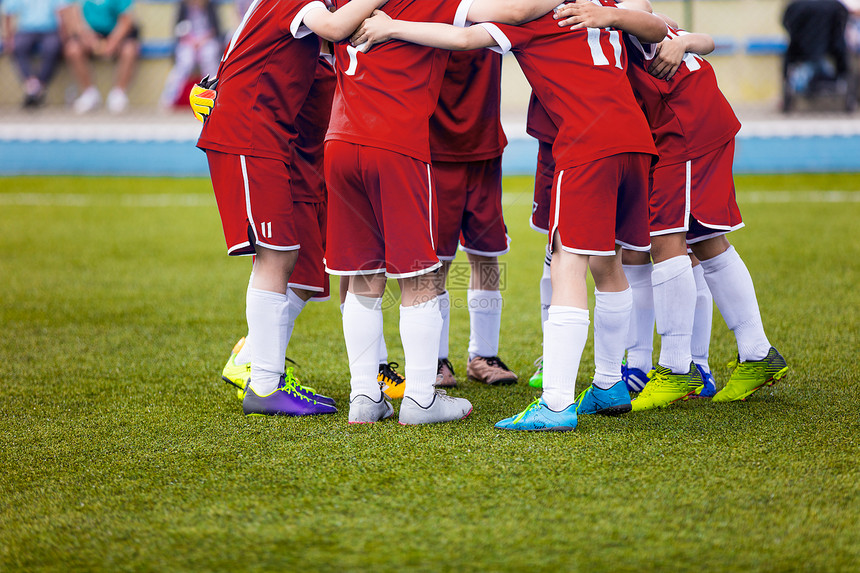 穿着红色运动服的年轻足球运动员球场上的年轻运动队决赛前的鼓舞人心的谈话足球学校锦标赛运动图片