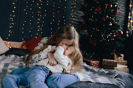 女孩拥抱和亲吻小妹两个可爱的小女孩圣诞装饰品图片