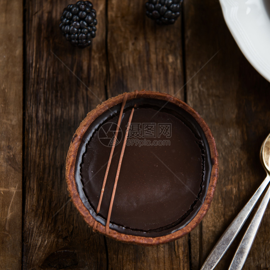 以短结薄粉和极滑的比利时巧克力甘纳奇制成的手工制富含巧克力罐头图片