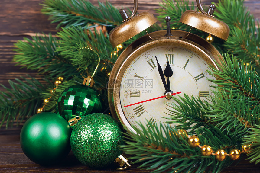 新年钟和带有圣诞球的冷杉树枝图片