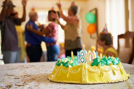 一群老朋友和家人在养老院庆祝老年男子80岁生日晚会背景图片