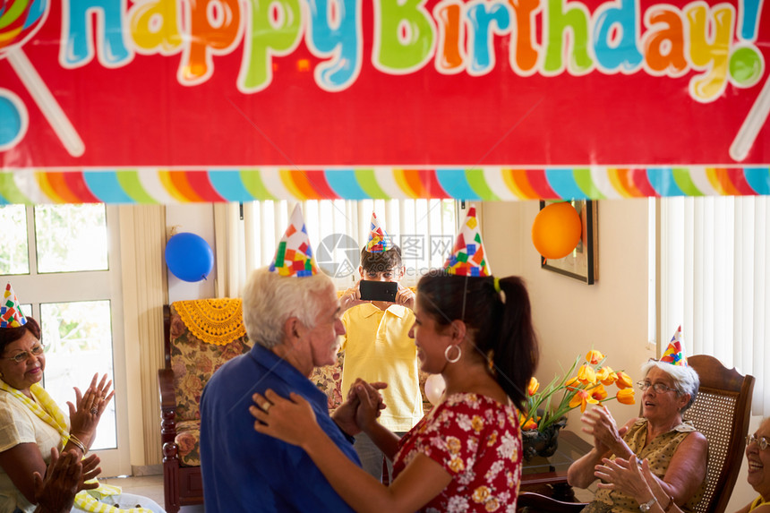 家人庆祝老年男子在疗养院的生日图片