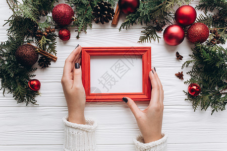 美丽的圣诞装饰女手中的红相框白色木制图片