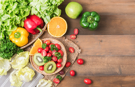 新鲜沙拉蔬菜和水果番茄甜椒欧芹木背景猕猴桃概念饮图片
