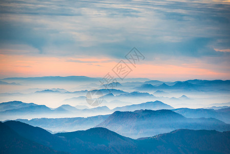 山和天空的日落蓝色山丘上的戏剧彩云图片