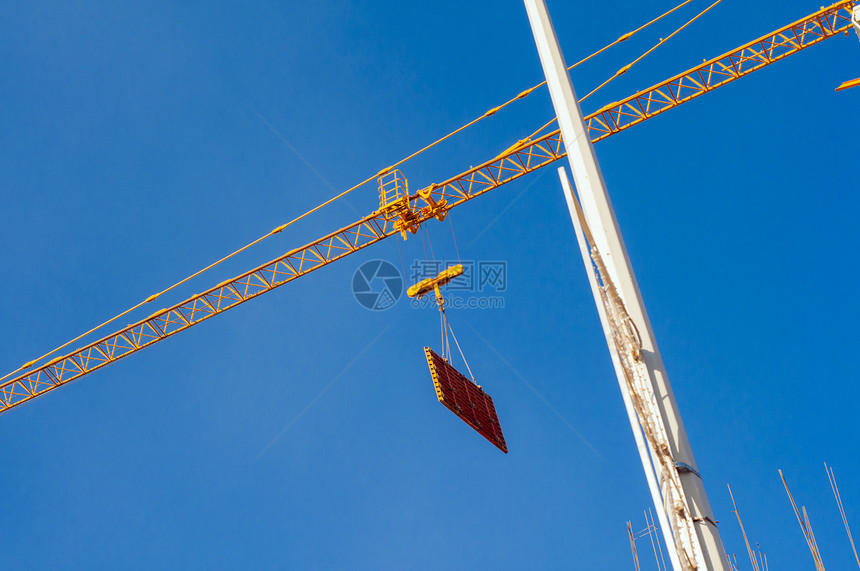 工业建筑起重机和建筑剪影在日出时的太阳工业起重机在阳光和蓝天下操作图片