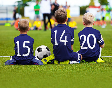 儿童足球队比赛孩子们的足球比赛坐在球场上的年轻足球运动员穿着蓝色足球图片