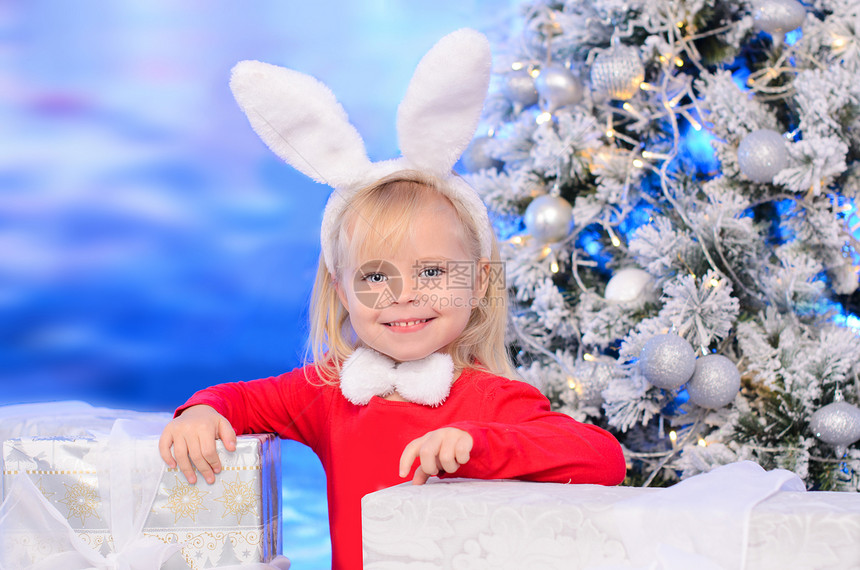 在圣诞树附近的红球衣和兔耳朵里笑着图片