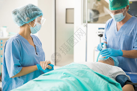 一对夫妇医生用特殊工具向病人进行除颤图片