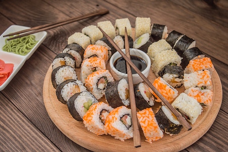 寿司将生鱼片和寿司卷放在木板上图片