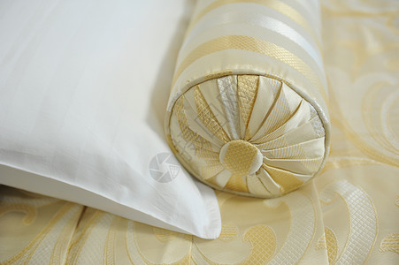 床铺上装饰枕头的金织物图片