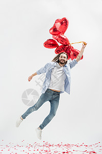 年轻人在心形空气球上飞翔图片