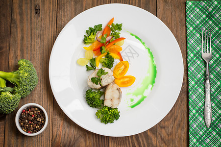 煮鲈鱼配蒸蔬菜完全健康的一餐木制背景图片