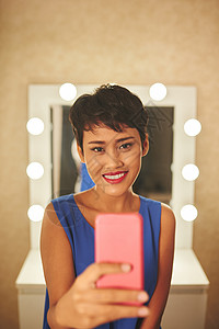 漂亮微笑的女人在镜子前自拍图片