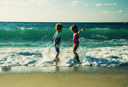 日落时在沙滩上玩耍的孩子图片