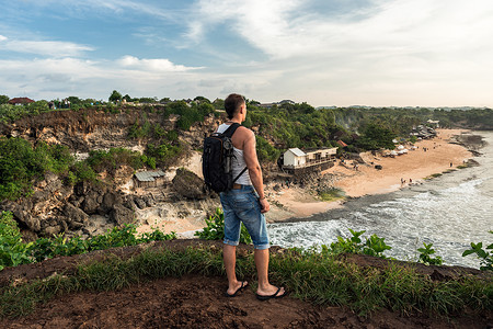 从悬崖往前看的男人巴兰甘海滩巴厘岛图片