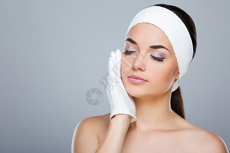 戴白色头巾的女人戴着白手套用手抚摸脸颊闭着眼睛的模特头和肩膀美容院图片