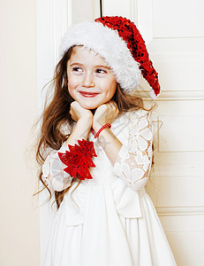 穿着圣塔红帽子的可爱小女孩在等待圣诞礼物图片