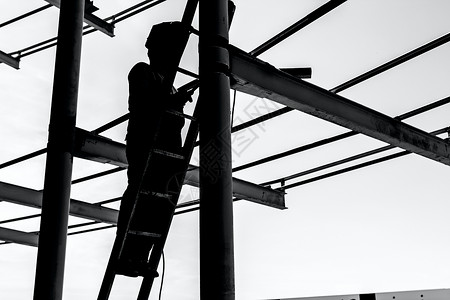 利用木制梯子焊接金属板的建筑工人的工业针图片