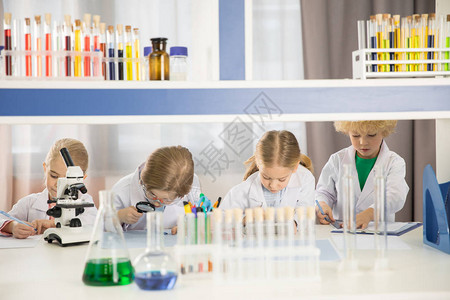 身着实验室大衣的在校儿童在化学实背景图片