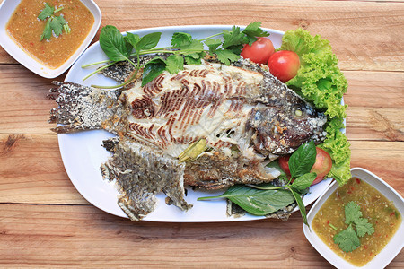 蒂拉皮亚鱼在白盘中用盐烧烤图片