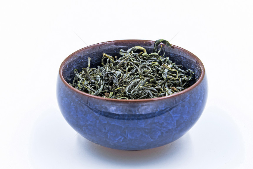 绿色茶黄山峰在一个蓝色陶瓷碗里图片