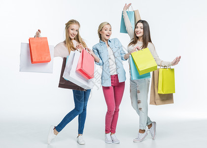 兴奋的青年妇女带着色彩多的购物袋在白图片