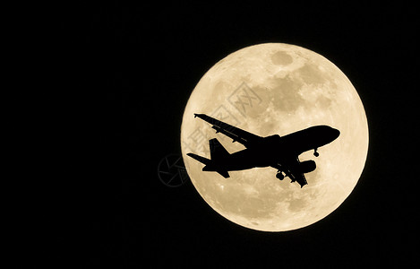 飞机和超级月亮满月的剪影图片