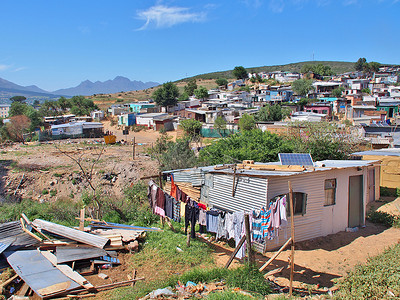 非正式定居点南非西开普省斯泰伦博斯郊区的恩卡尼山和蓝天恩卡尼的许多棚屋都有太阳能背景图片