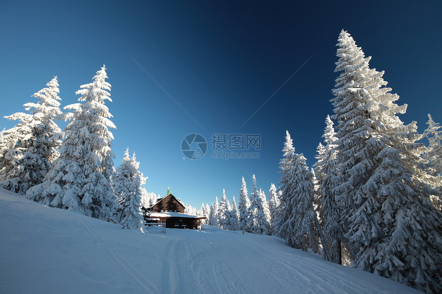 山中的小屋被冬天的景色所环绕图片