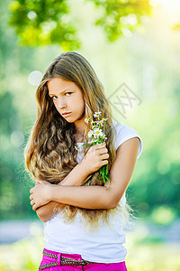 美丽笑容的年轻女孩带着野地花朵绿色图片