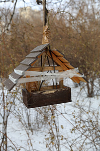 大雪纷飞的冬季城市公园的鸟舍喂食器背景图片