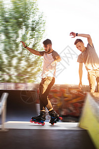 年轻人滚车两个人在户外玩滑背景图片