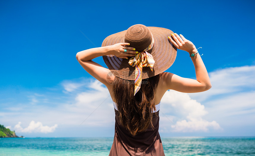 暑假妇女穿着草帽和沙滩服装在海洋享受风图片