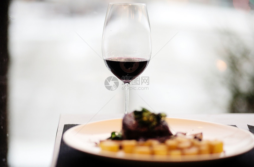 牛排配烤土豆和一杯红酒的照片图片