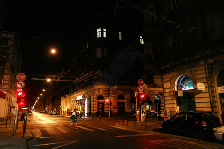 在布达佩斯市的街头晚夜生活汽车和步行者以及温暖灯图片