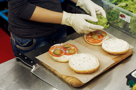 厨师亲手操作手套烹饪汉堡包和芝士汉堡图片