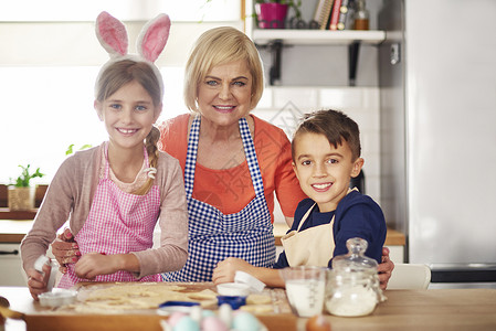 快乐孩子的肖像祖母在厨房做饭和外图片