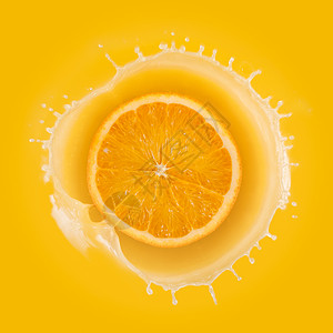 在黄色背景下用橙子泼橙汁图片