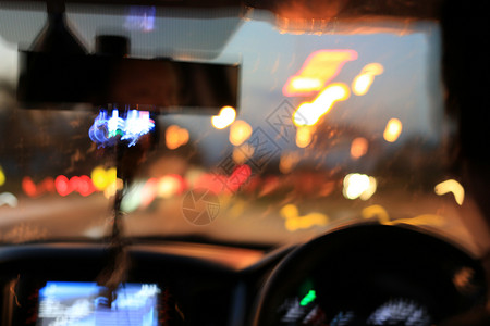 从车内自然光街道和其他汽车的夜路视图是运动模糊的图片
