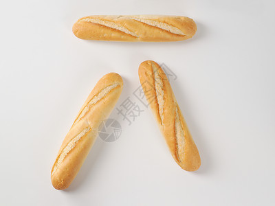 白色背景上的三个小法式长棍面包图片