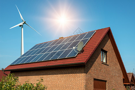 房子屋顶上的太阳能电池板和风涡轮环状圆形可持图片