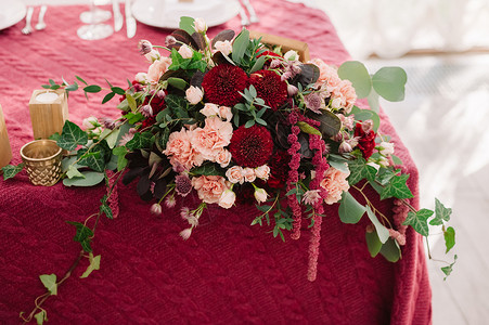 红布上的红色和粉红色花朵的婚礼餐桌装饰图片